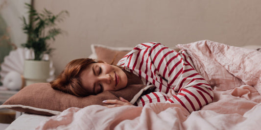 a woman sleeping deeply while smiling to herself