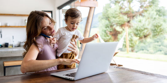 a mother and young child looking at a laptop