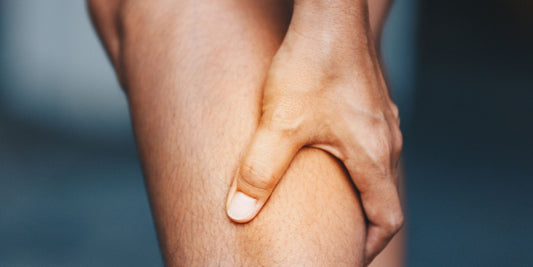 a hand gripping a leg and massaging sore muscles