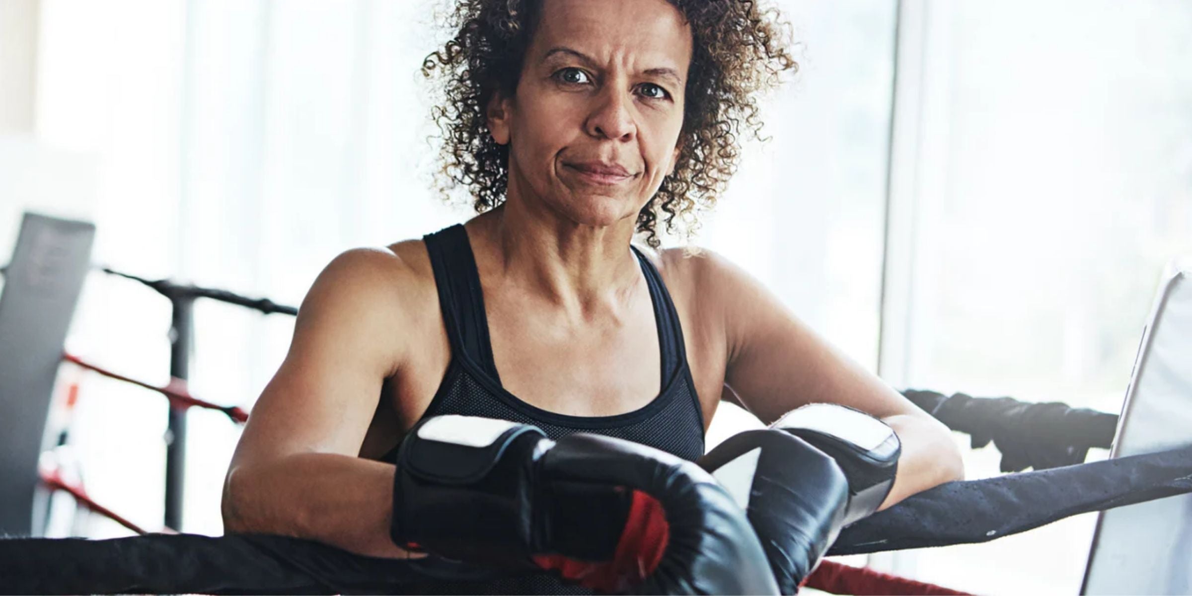 a mature woman in a boxing ring wearing boxing gloves