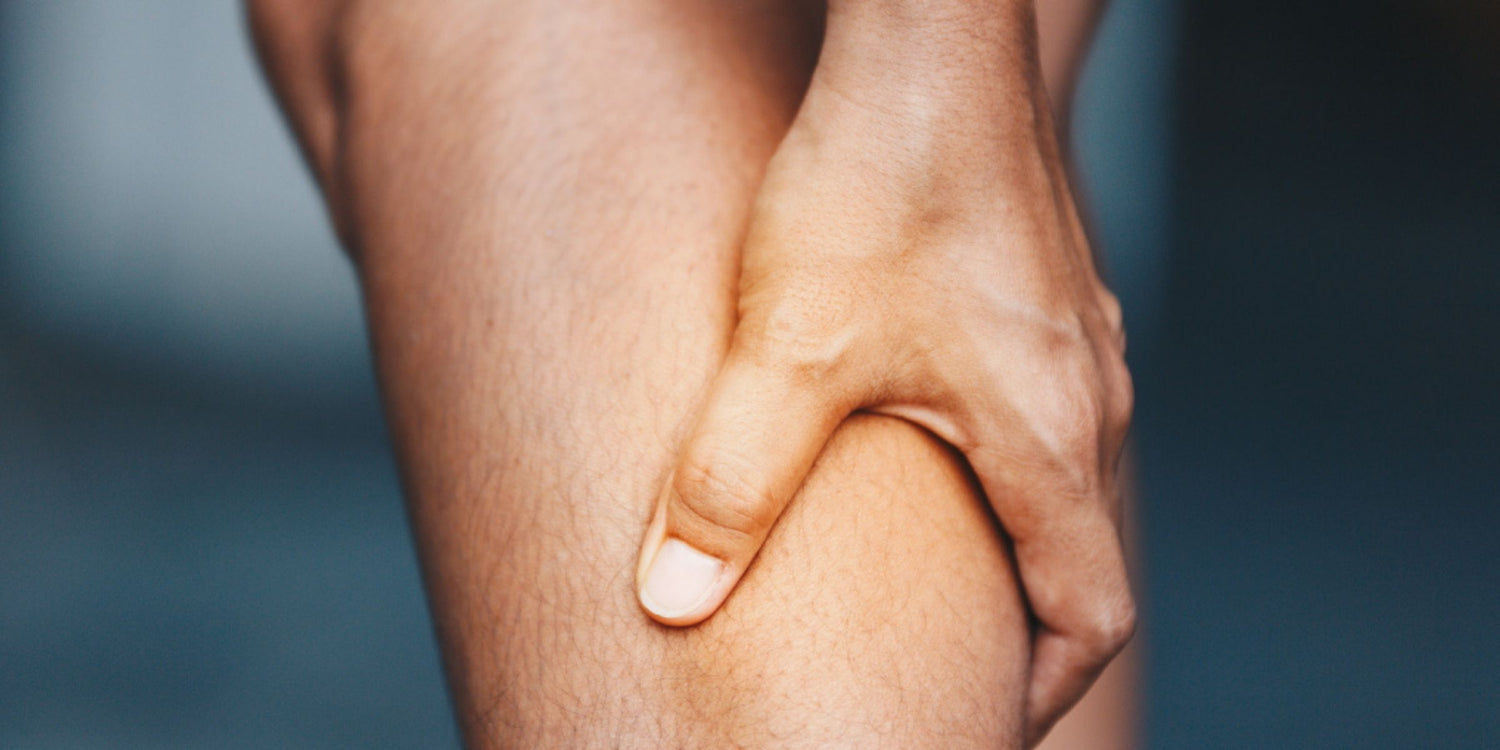 a hand gripping a leg and massaging sore muscles