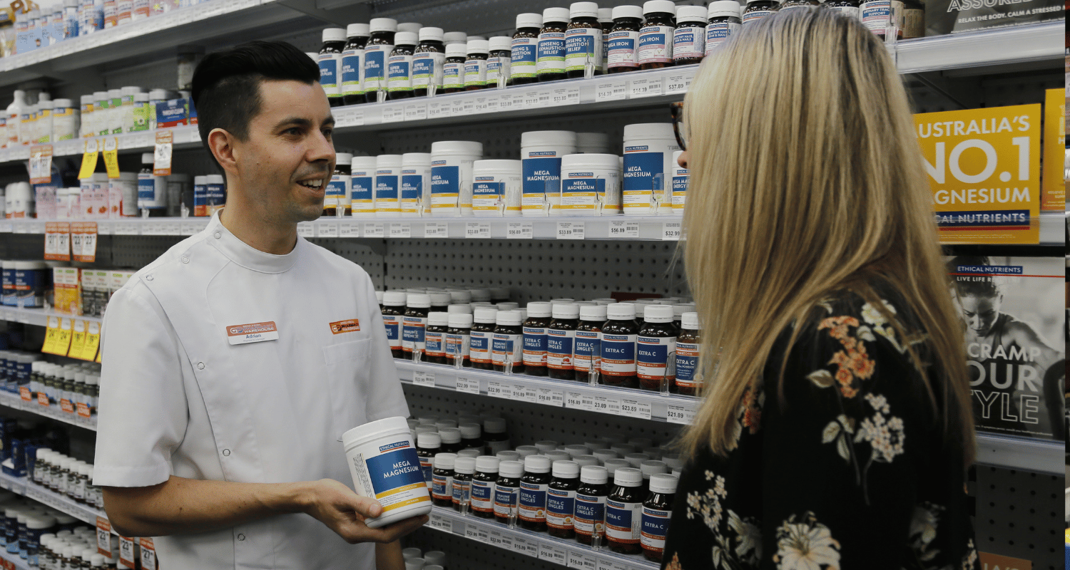 Pharmacist showing a customer ethical nutrients mega magnesium
